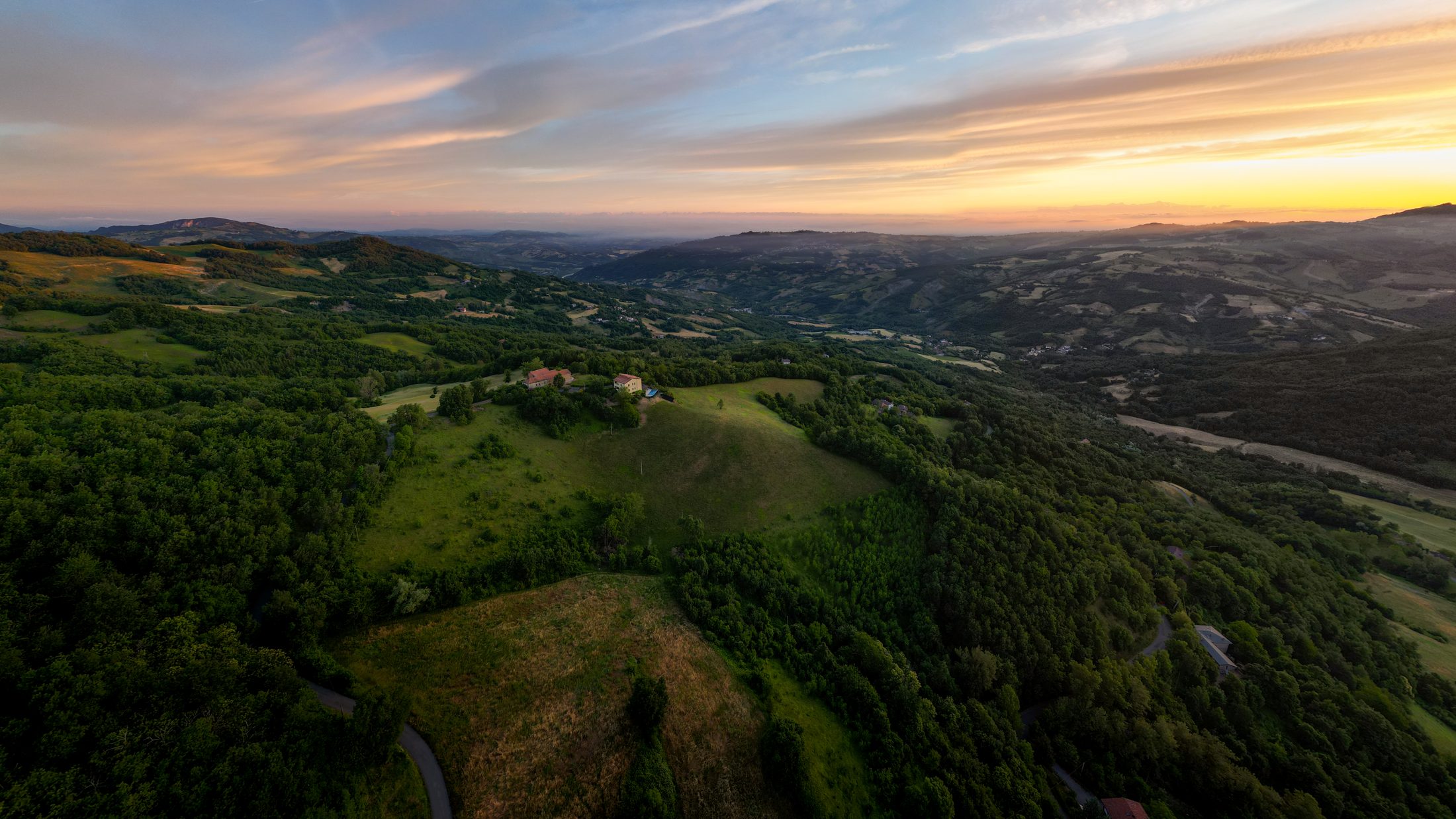 Aerial view of the green hills surrounding the property at sunset