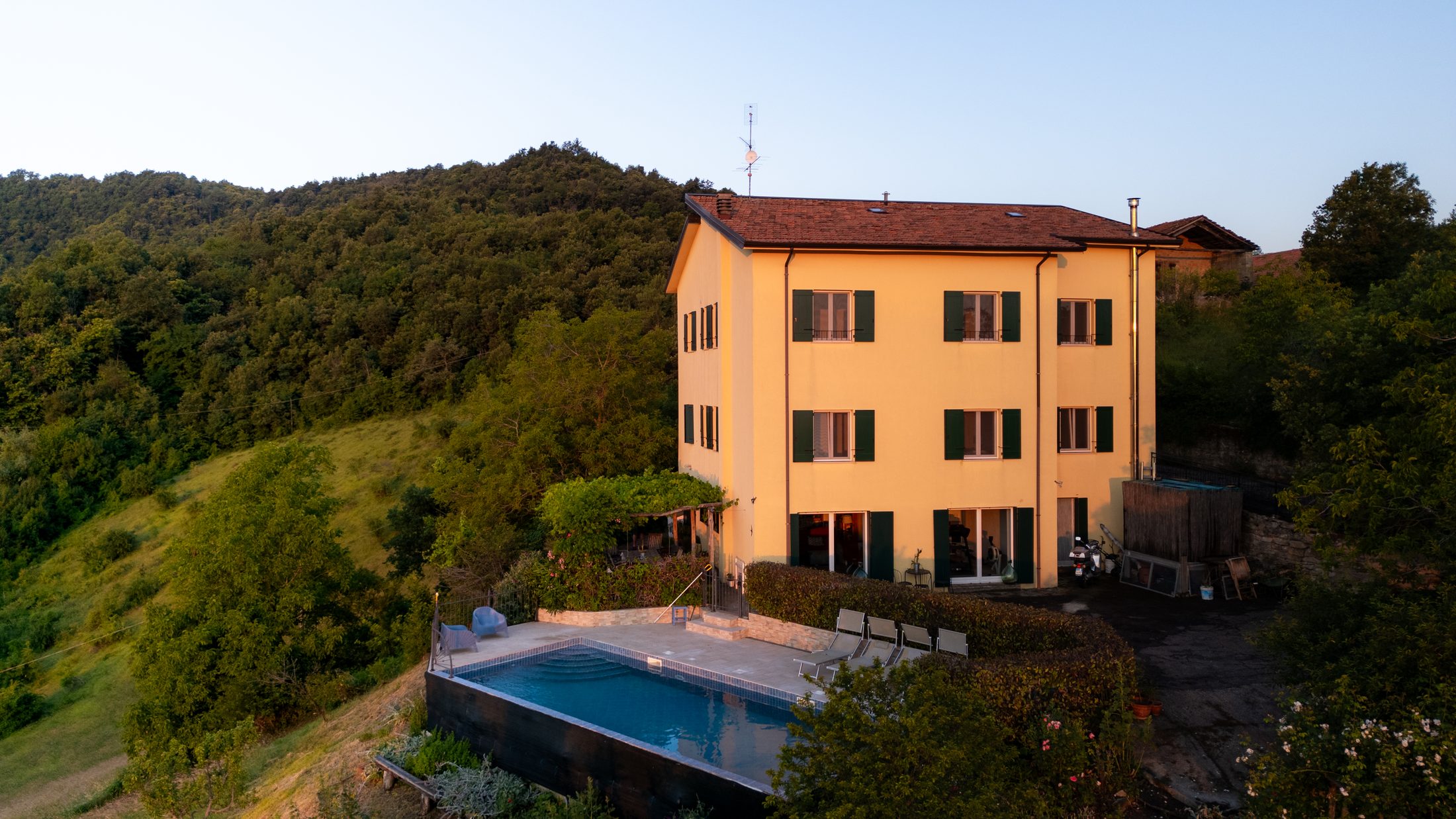 Casa Lunga Nuova at golden hour, with the pool and surrounding hillside