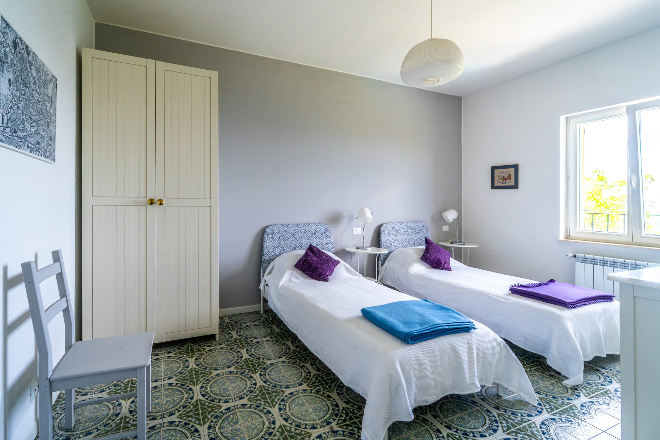 Twin bedroom with patterned tile floor