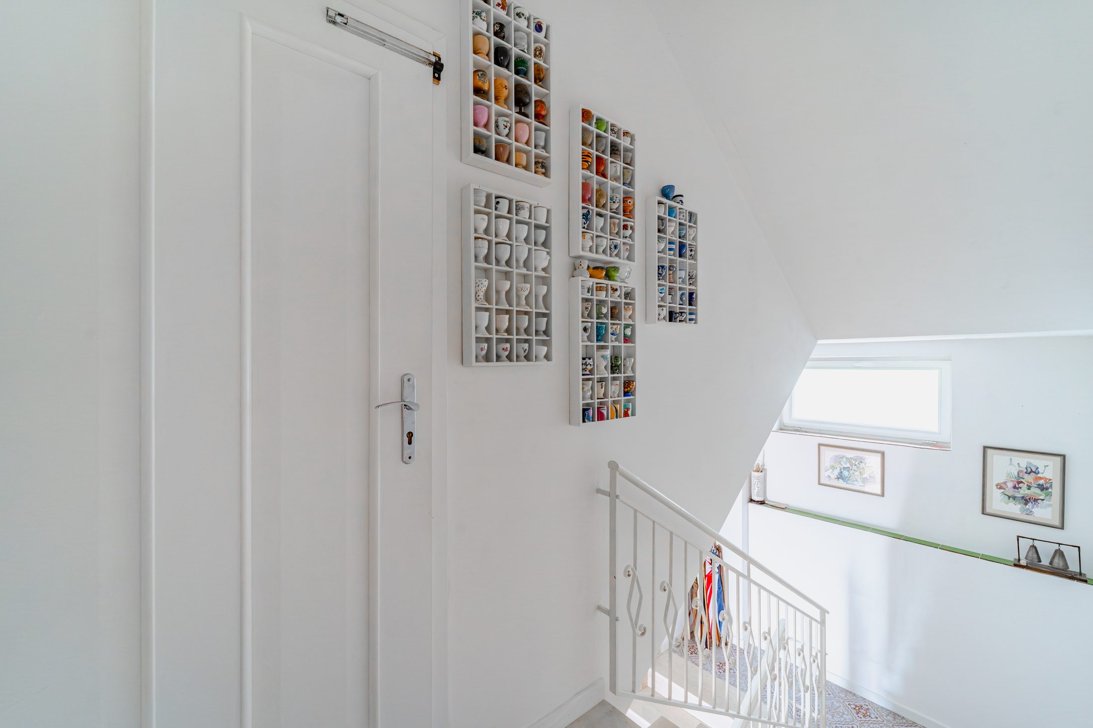 Upper landing with white door and framed artwork on the wall