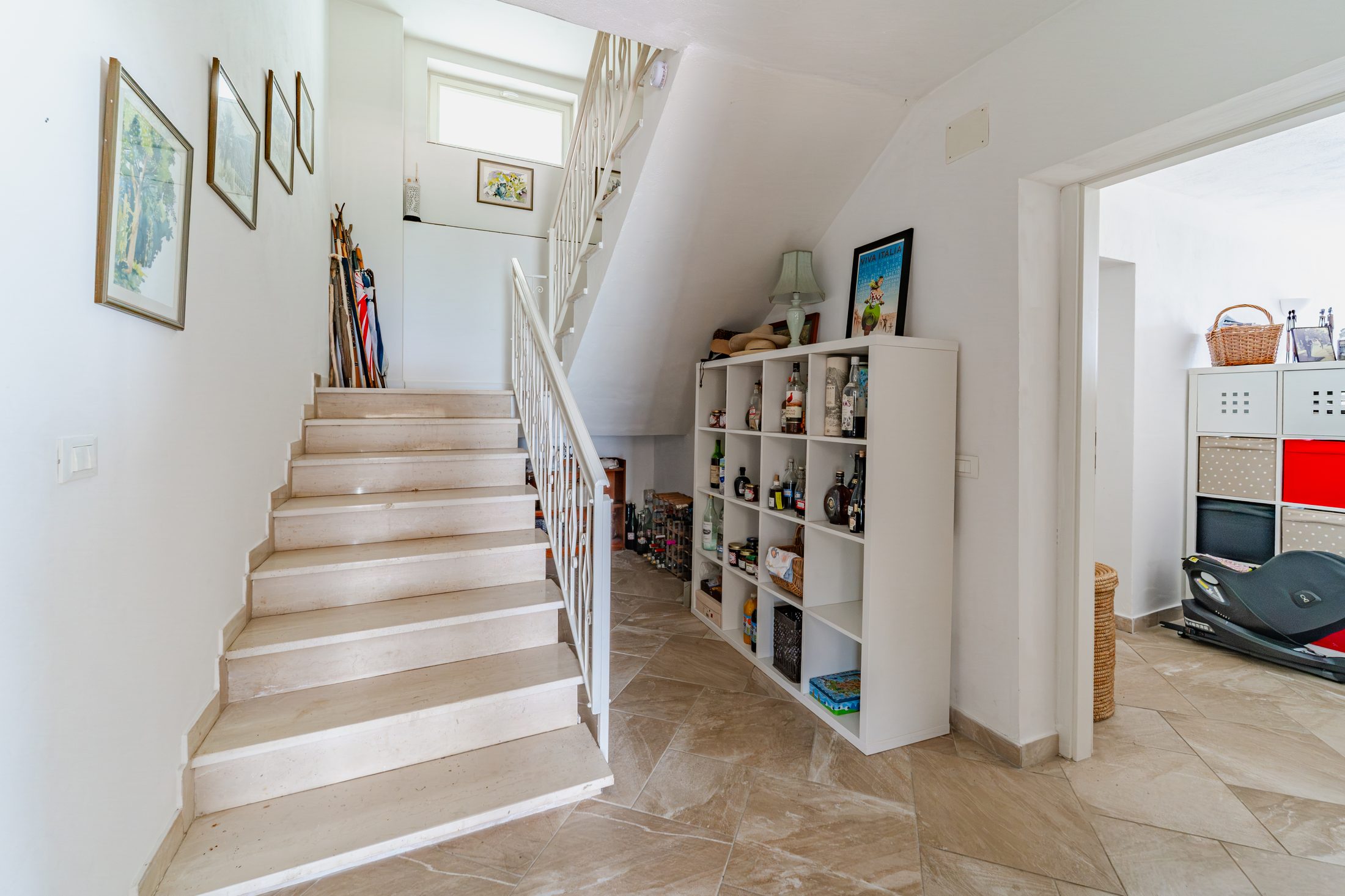 Lower staircase with framed botanical prints and built-in shelving