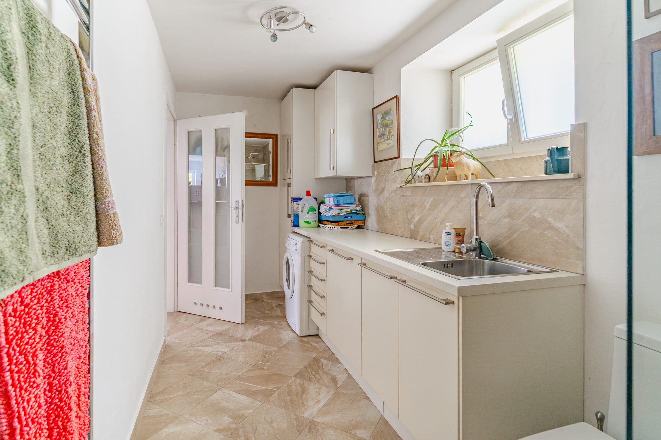 Laundry area with washing machine and sink
