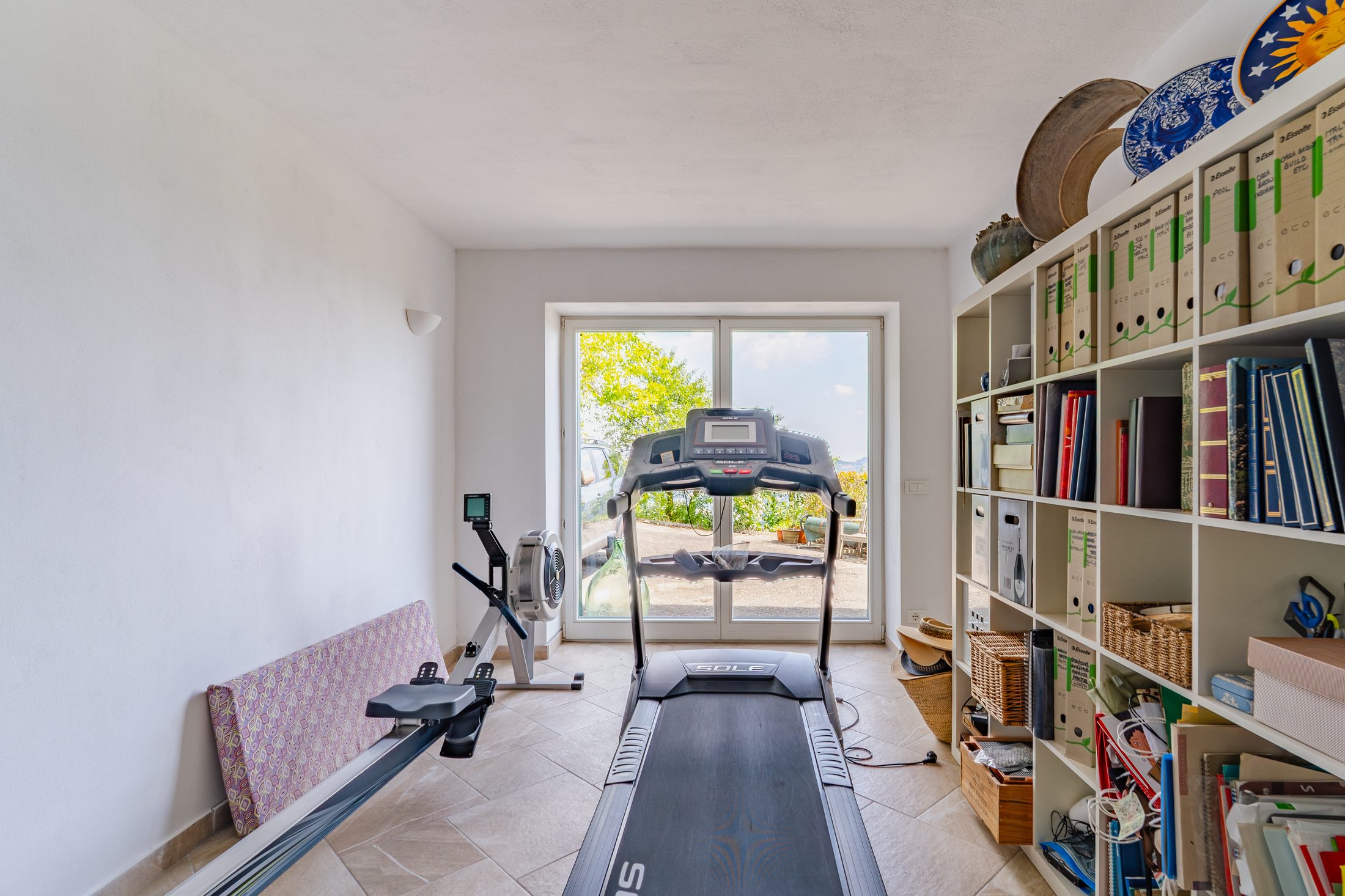 Home gym with treadmill and rowing machine, looking out to the garden