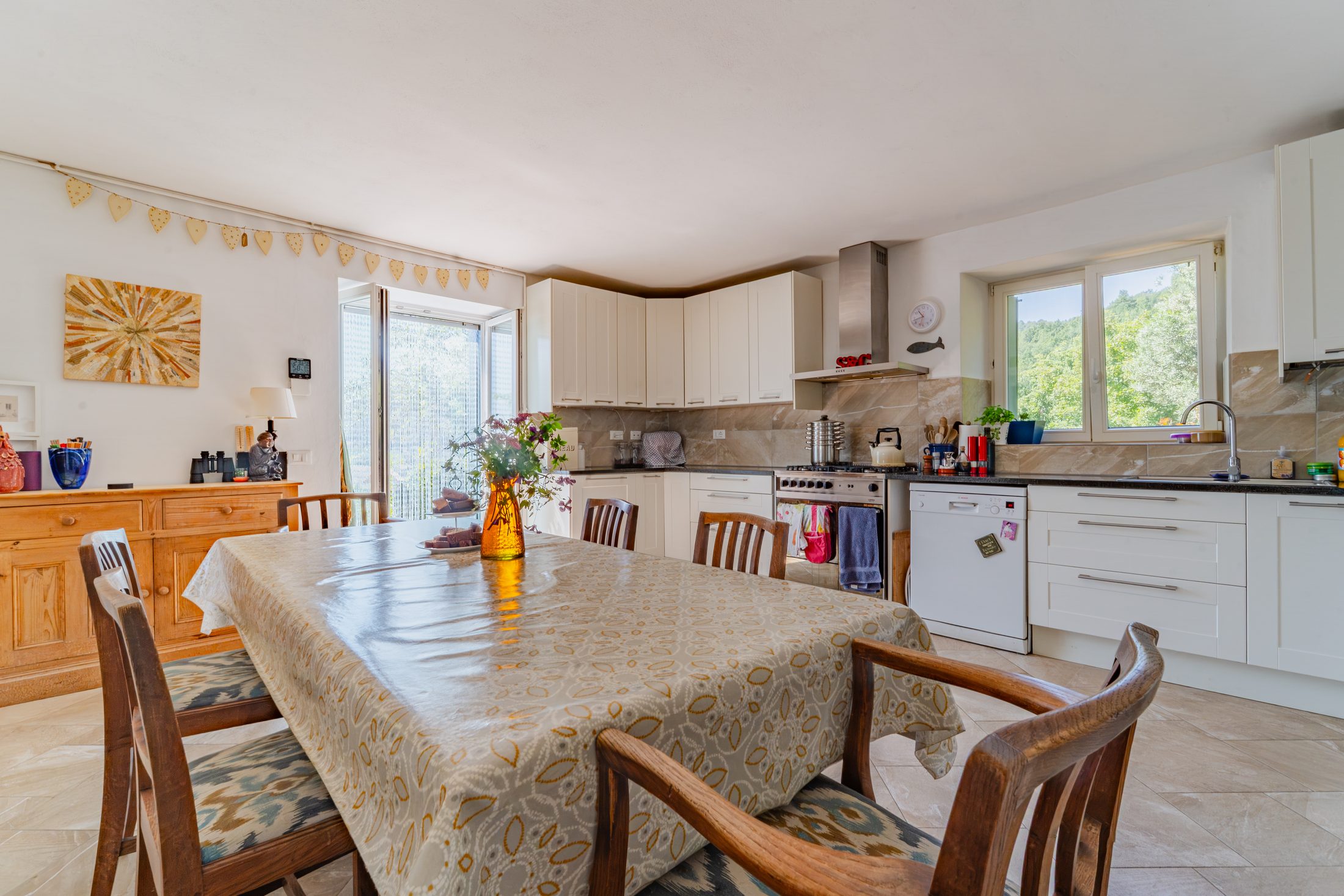 Dining table set for breakfast, with kitchen beyond
