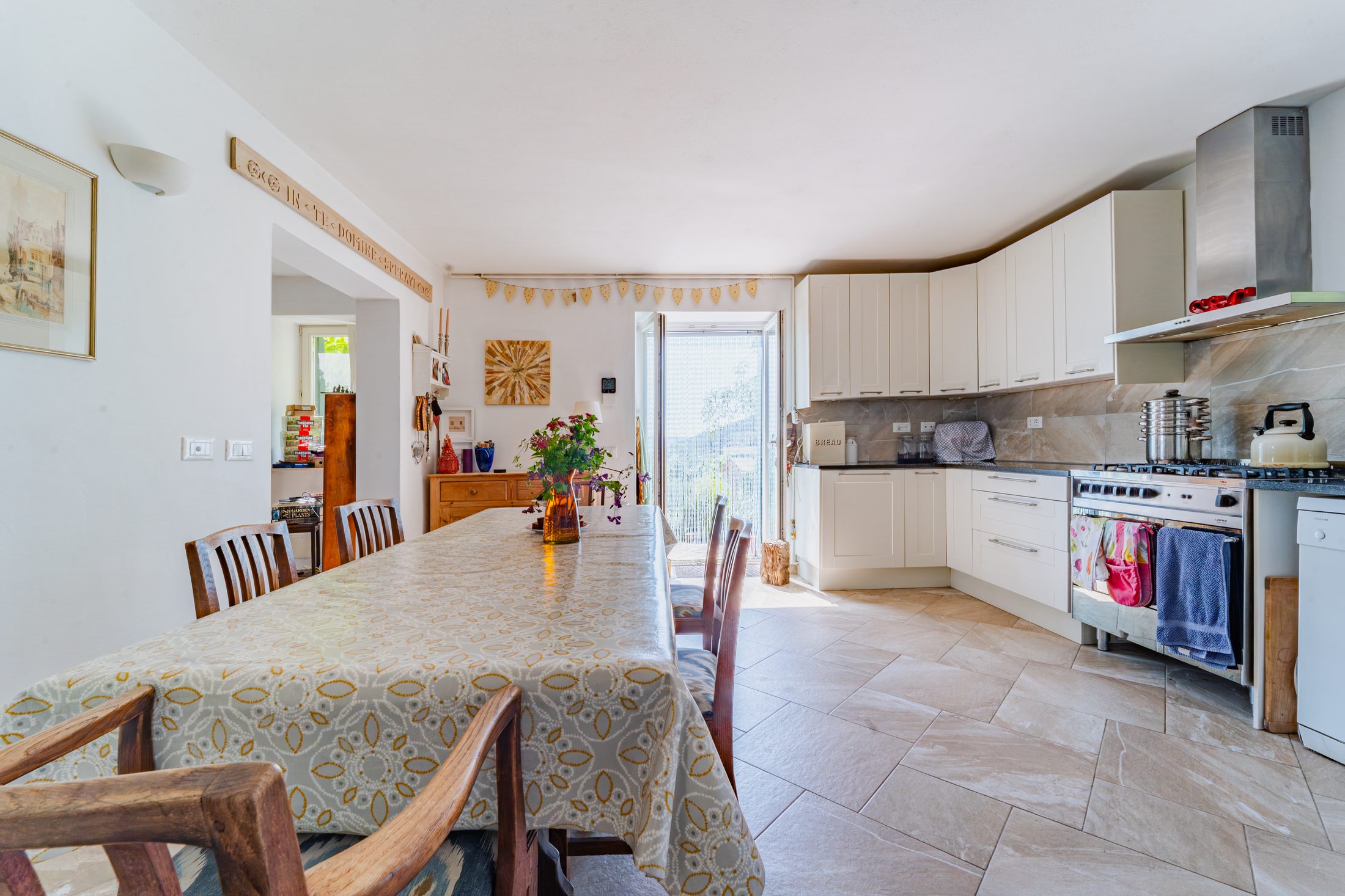 Open-plan kitchen and dining area, with the sitting room visible beyond